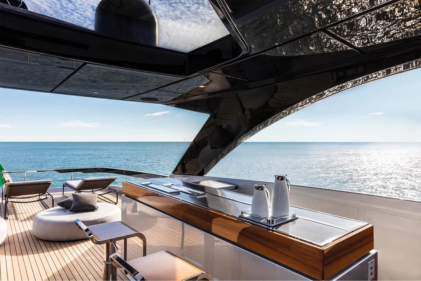 a table and chairs on a deck overlooking a body of water aboard RIVA 90' ARGO Yacht for Sale