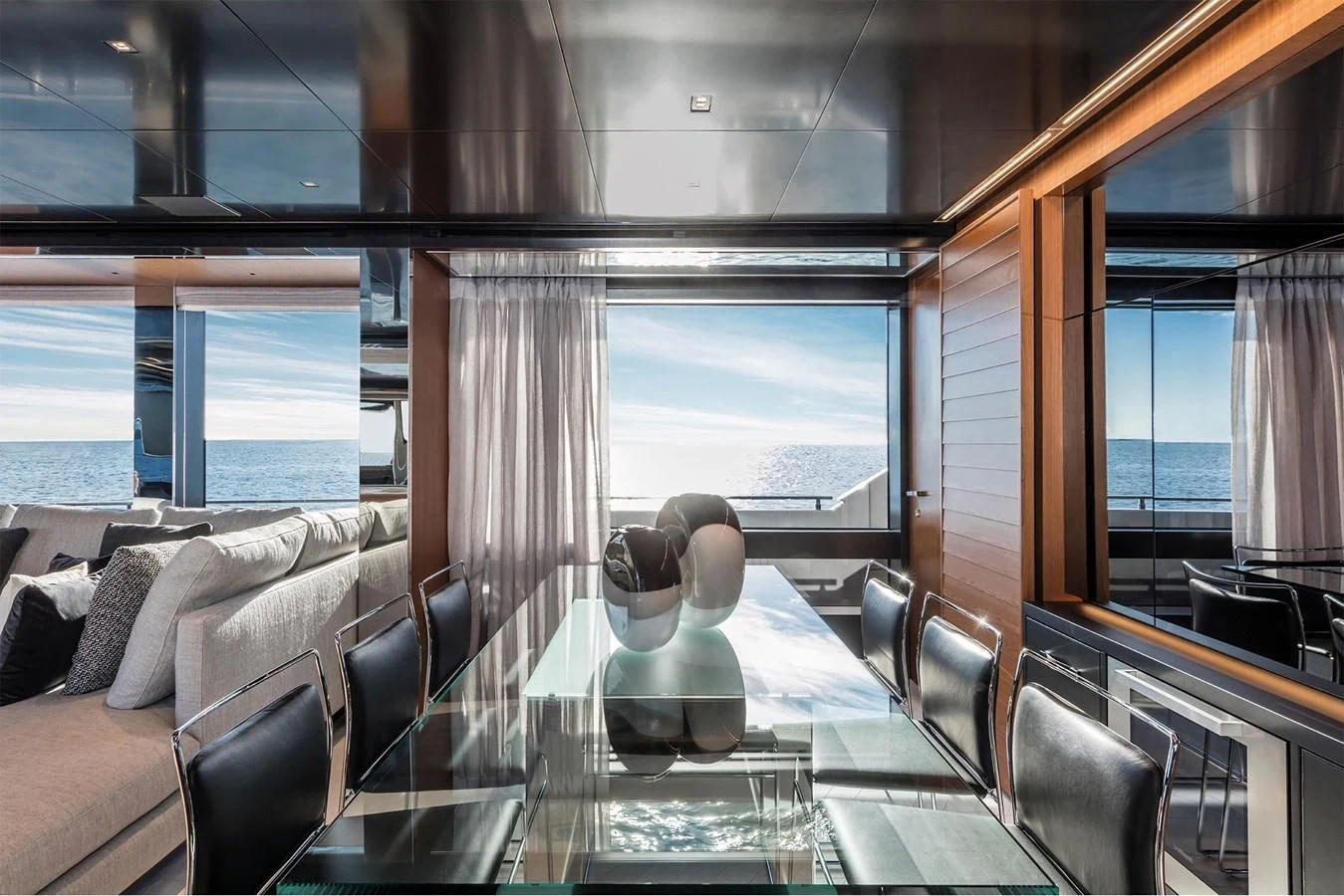 a room with a large window and a table with chairs and a view of the ocean aboard RIVA 90' ARGO Yacht for Sale