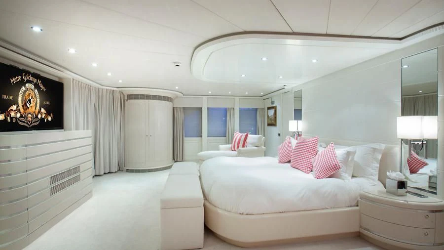 a large white bedroom with a large bed and a large television aboard BENIK Yacht for Charter