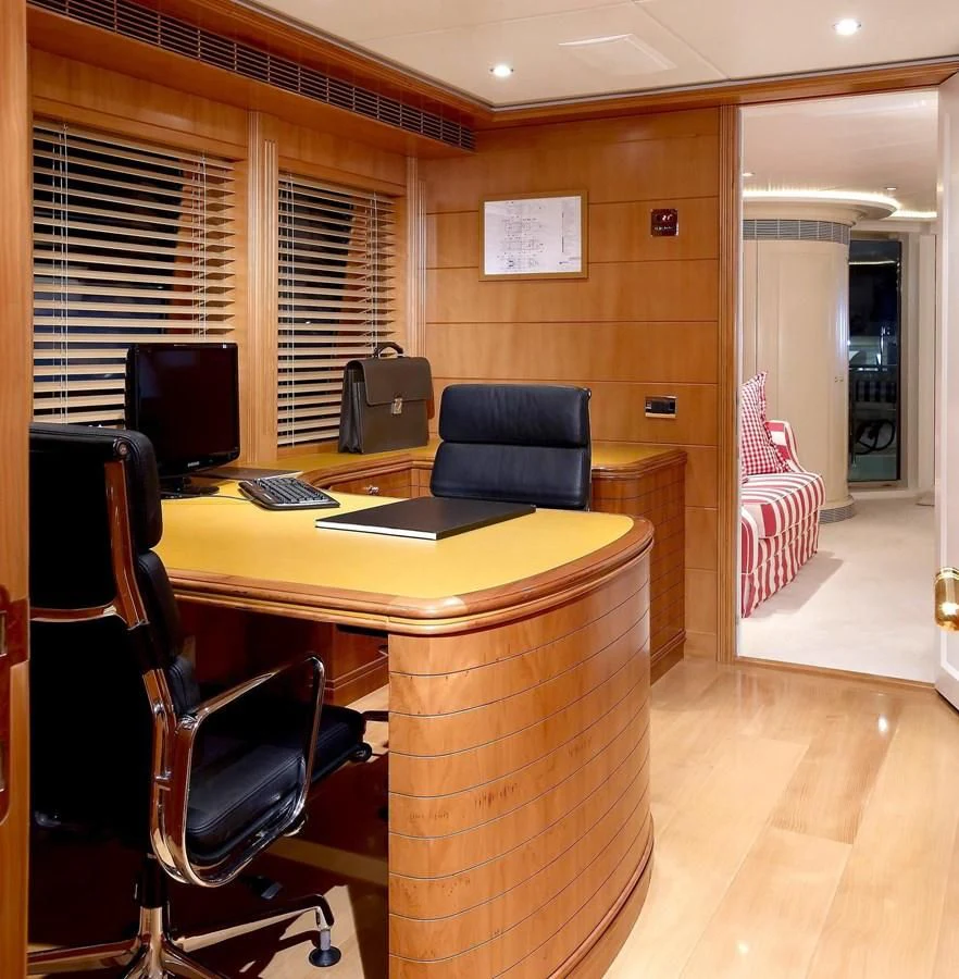 a room with a desk and chairs aboard BENIK Yacht for Charter