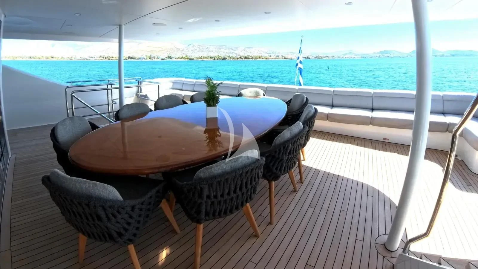a table and chairs on a deck overlooking a beach aboard BENIK Yacht for Charter