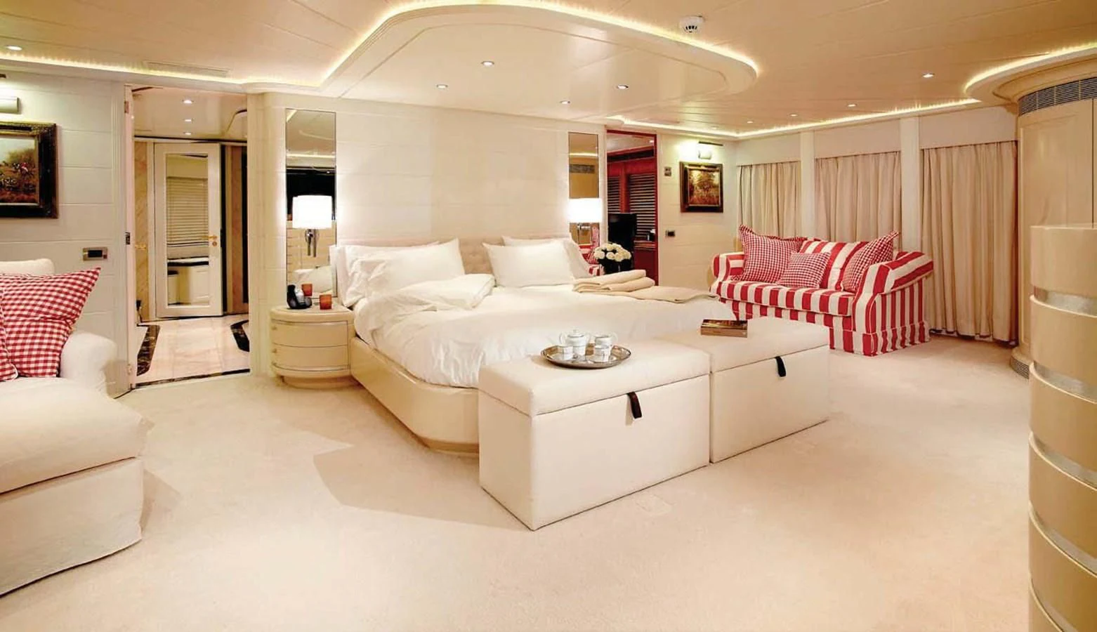 a large white room with a white bed and red pillows aboard BENIK Yacht for Charter