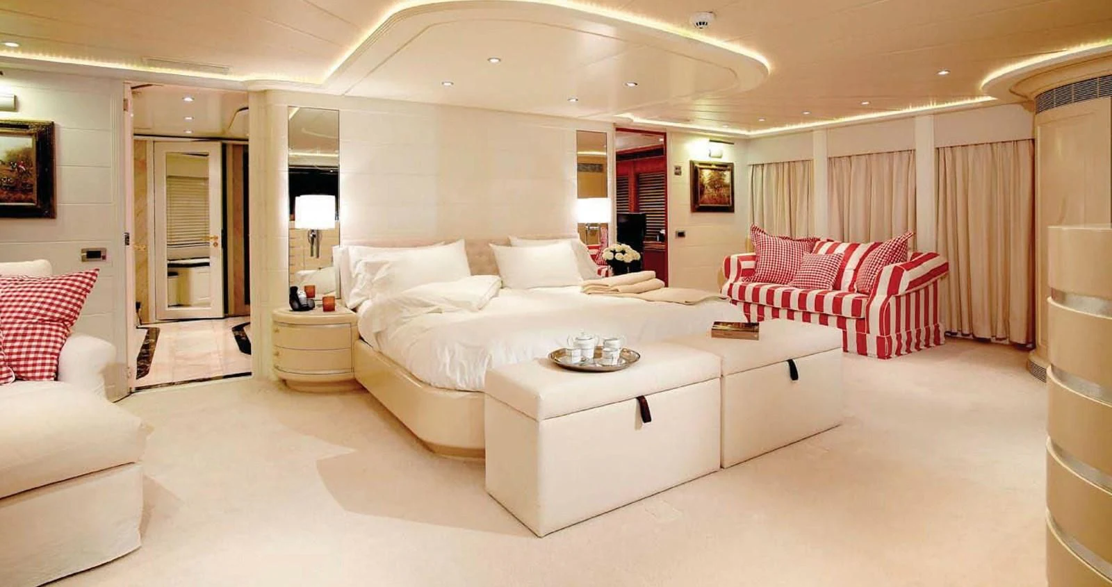 a large white room with a bed and a red couch aboard BENIK Yacht for Charter