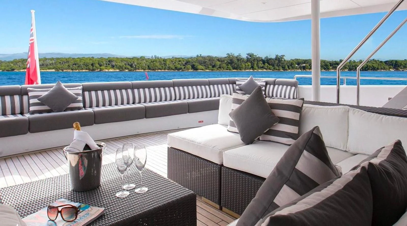 a couch and a table on a balcony overlooking a body of water aboard BENIK Yacht for Charter