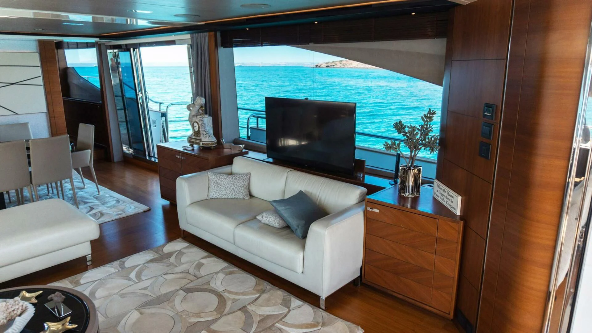 a living room with a large blue and white sofa and a large flat screen television aboard MOIRA CINCO Yacht for Sale