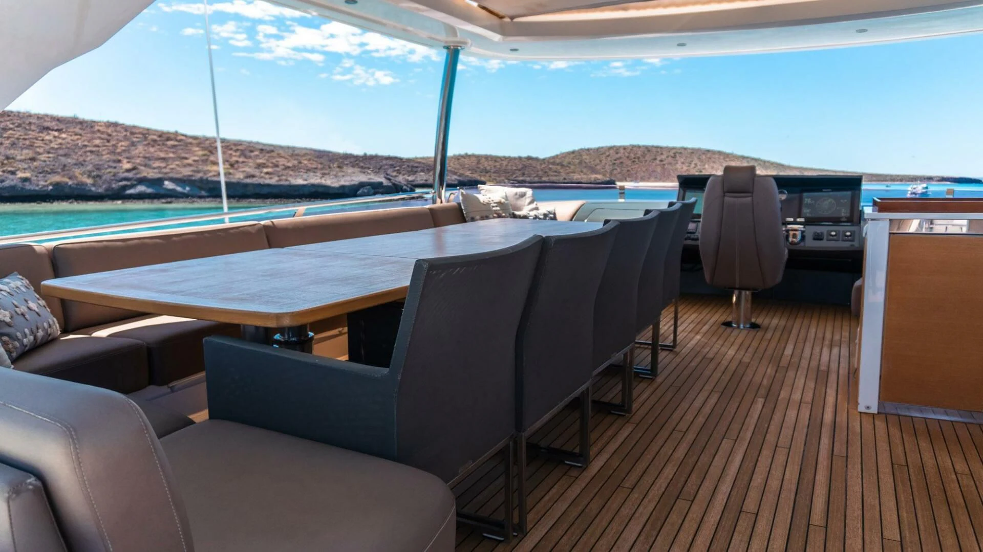 a deck with a pool and a deck with chairs and a large mountain range in the background aboard MOIRA CINCO Yacht for Sale