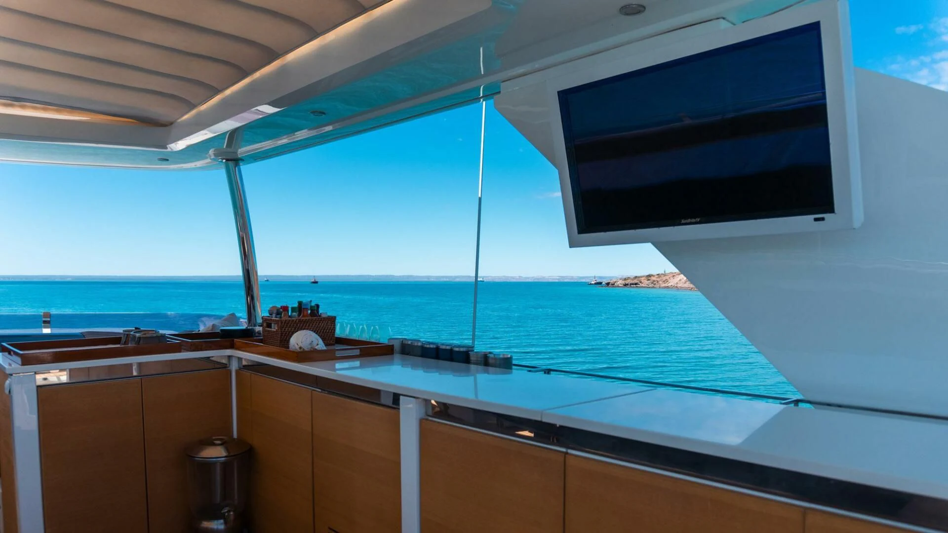 a large flat screen television on a white wall above a beach aboard MOIRA CINCO Yacht for Sale