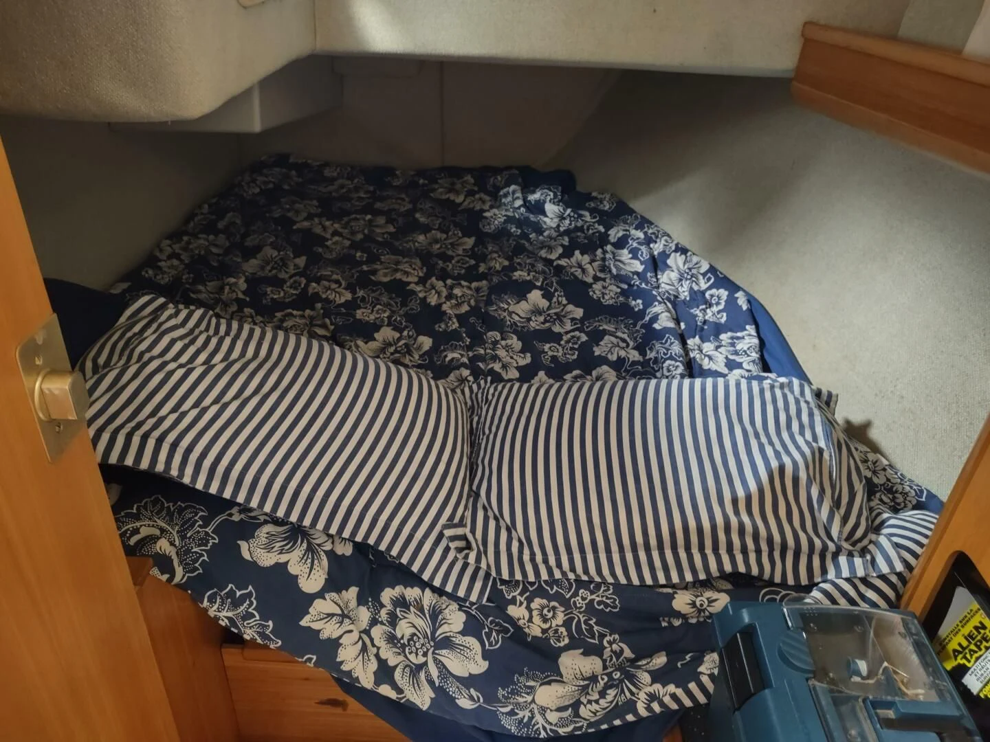 a bed with a blue and white blanket aboard ILLUSION XI Yacht for Sale