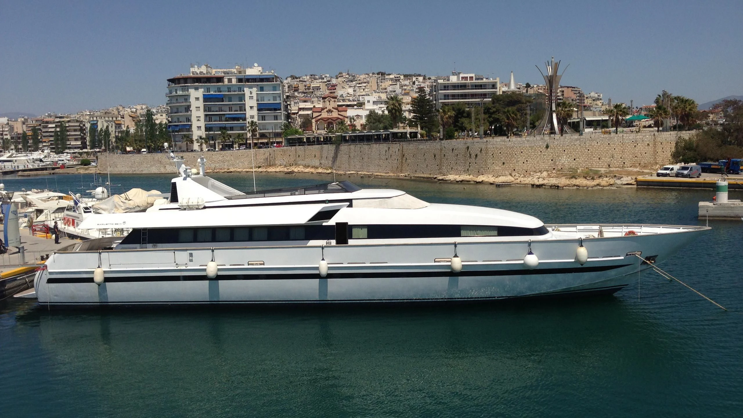 a white yacht in a harbor aboard ILLUSION XI Yacht for Sale