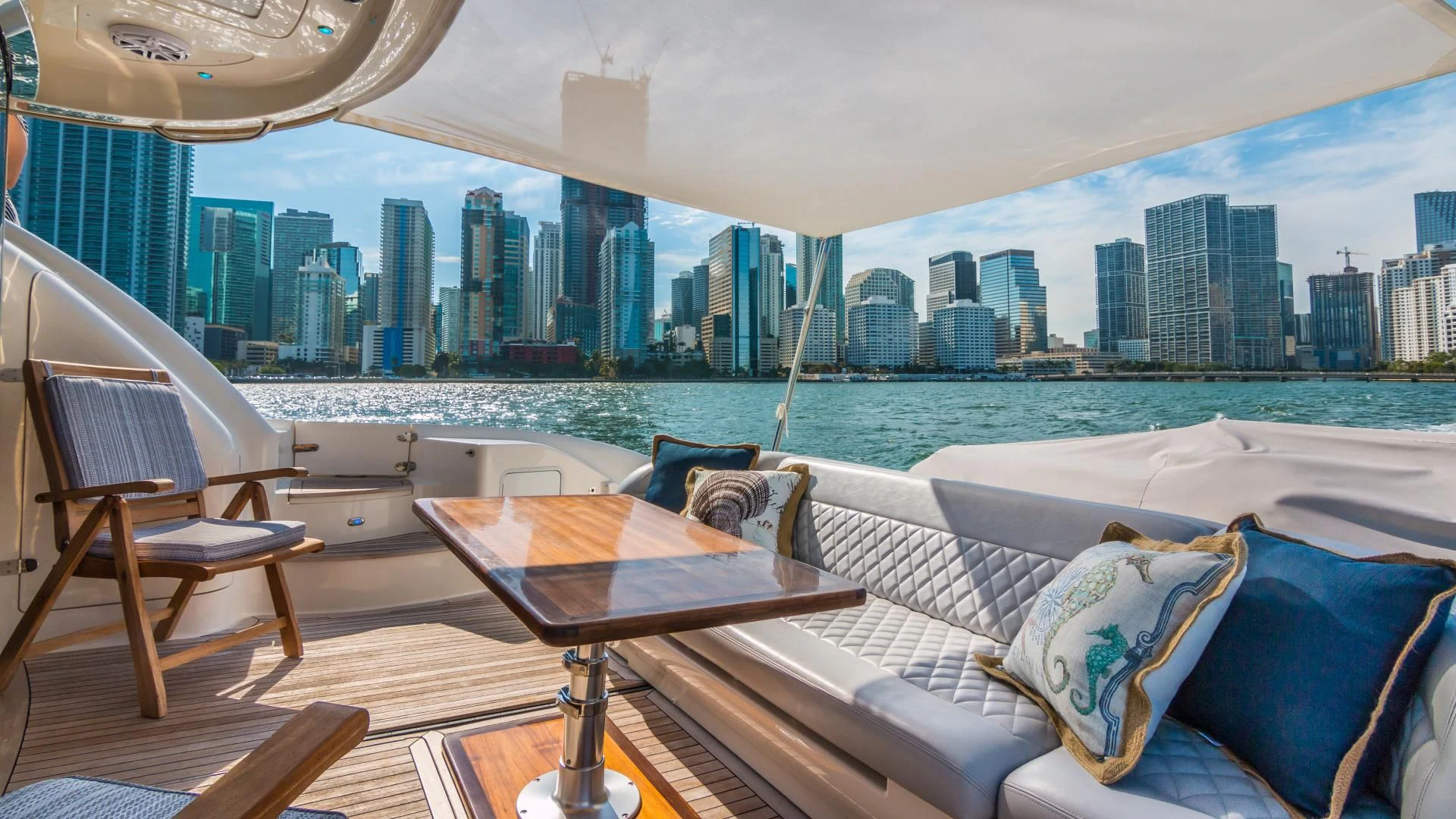 a room with a couch and a table and a city in the background aboard XANADU Yacht for Sale