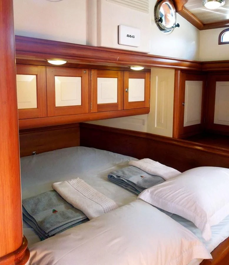 a bed with white sheets aboard COPIHUE Yacht for Sale