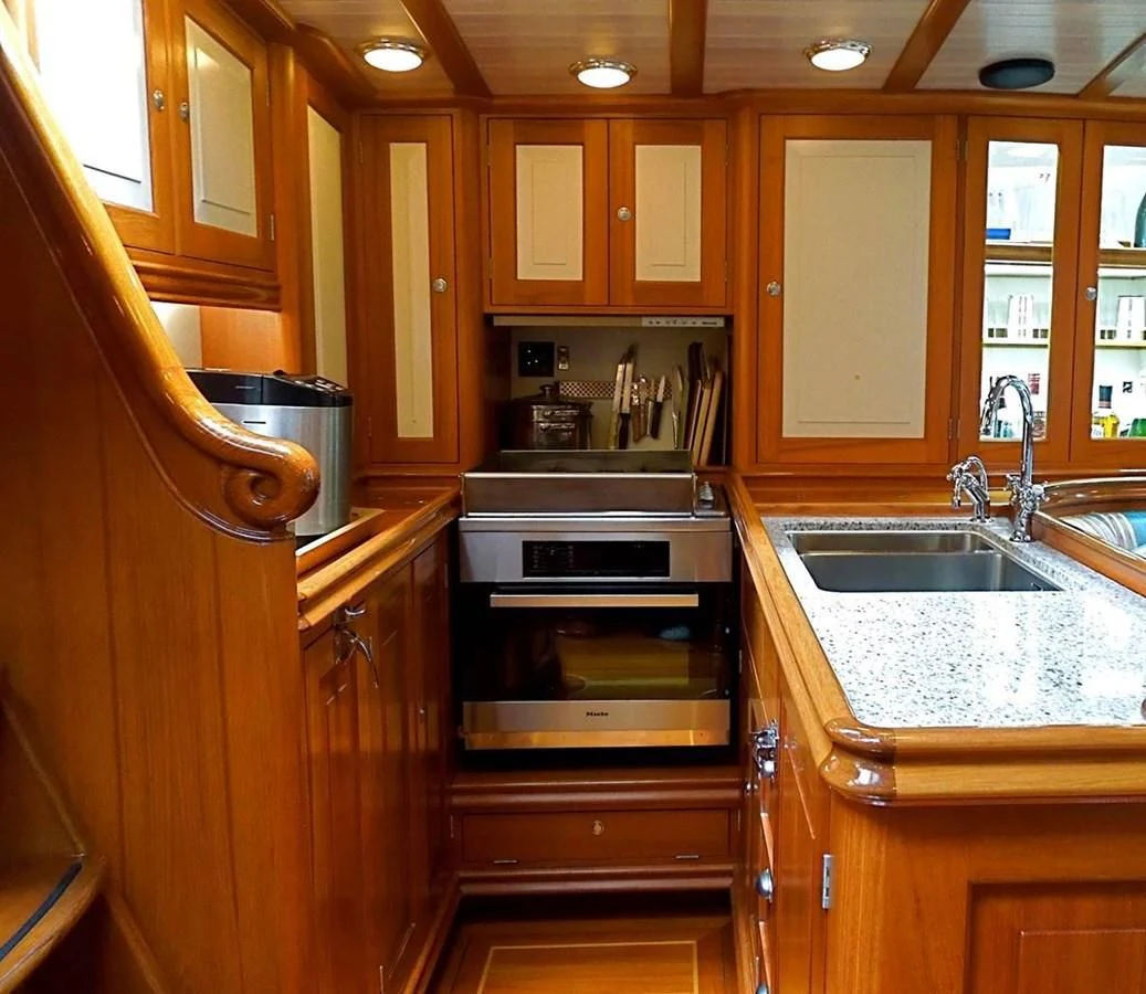 a kitchen with wooden cabinets aboard COPIHUE Yacht for Sale