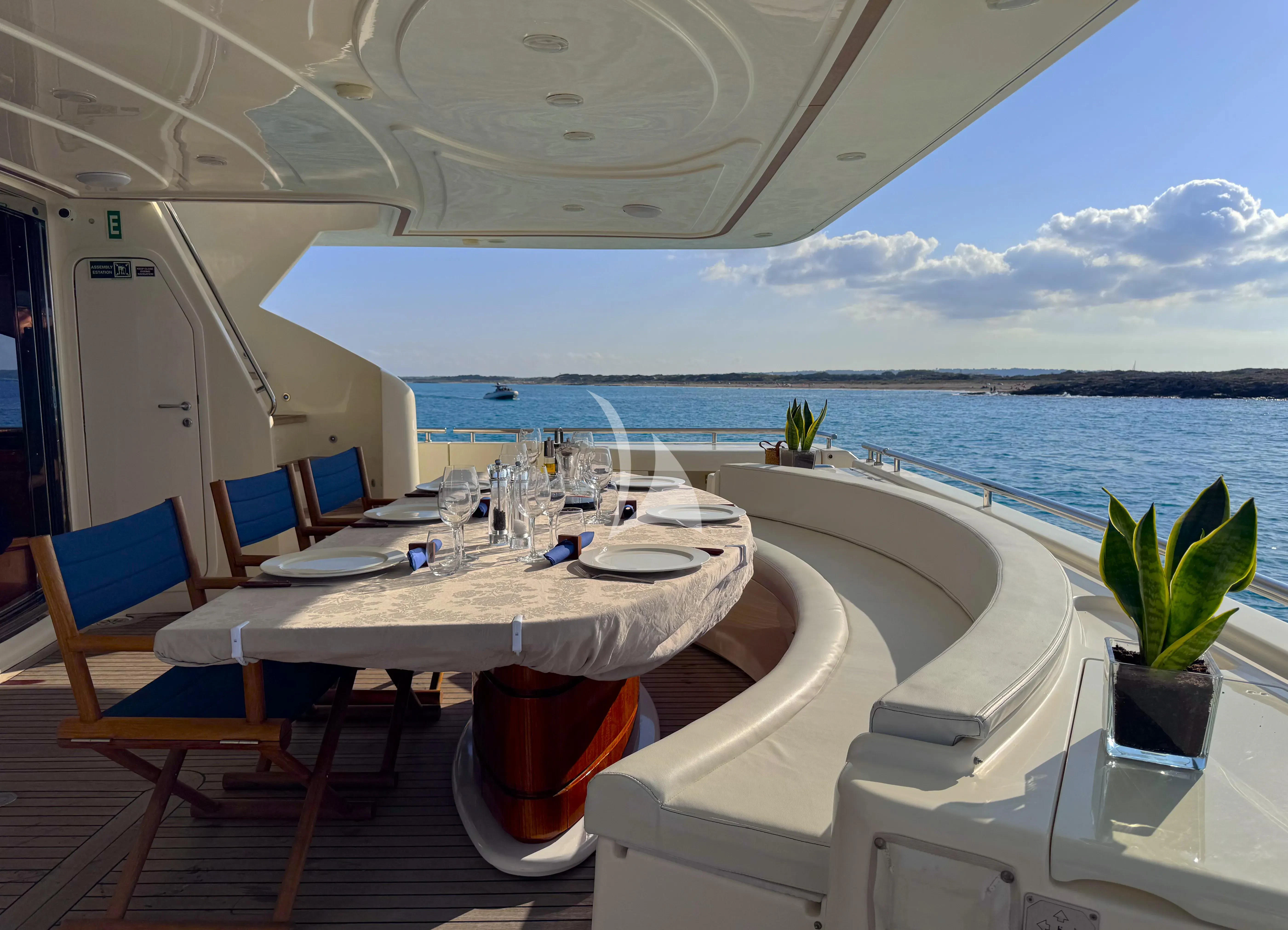 a table with chairs on it next to a large body of water aboard YOLO TOO Yacht for Charter