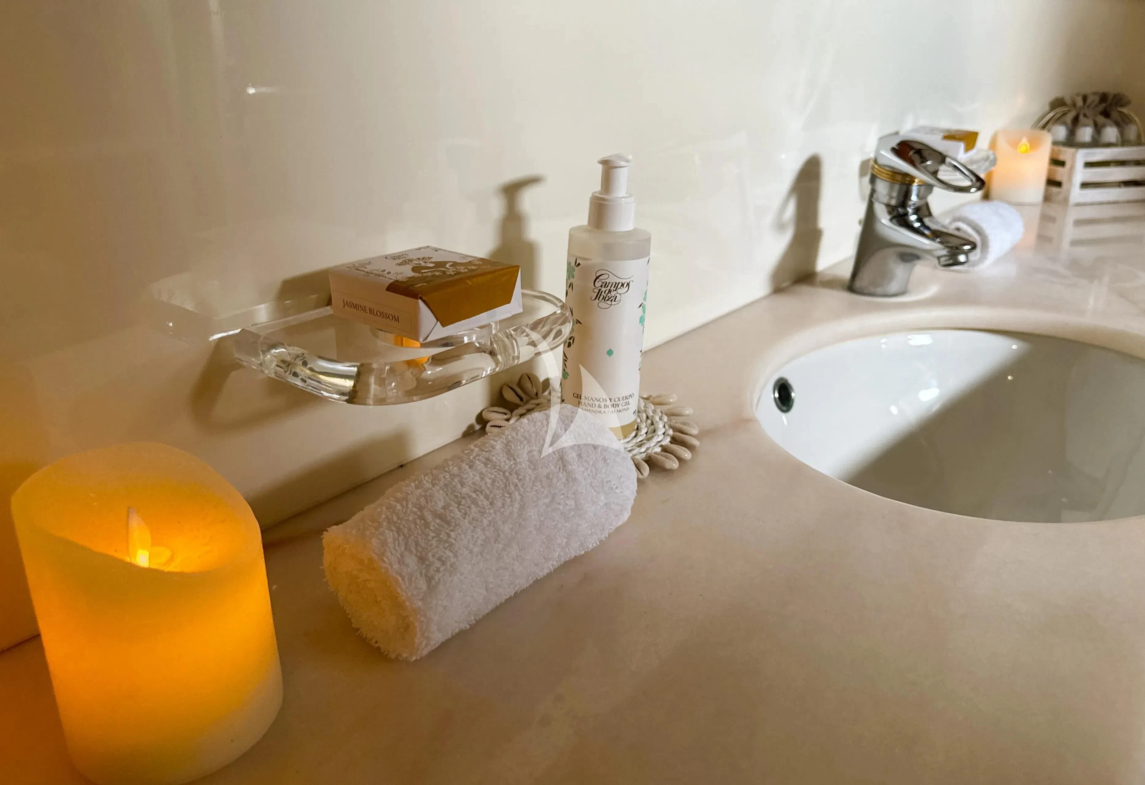 a bathroom sink with a towel and soap dispenser aboard YOLO TOO Yacht for Charter