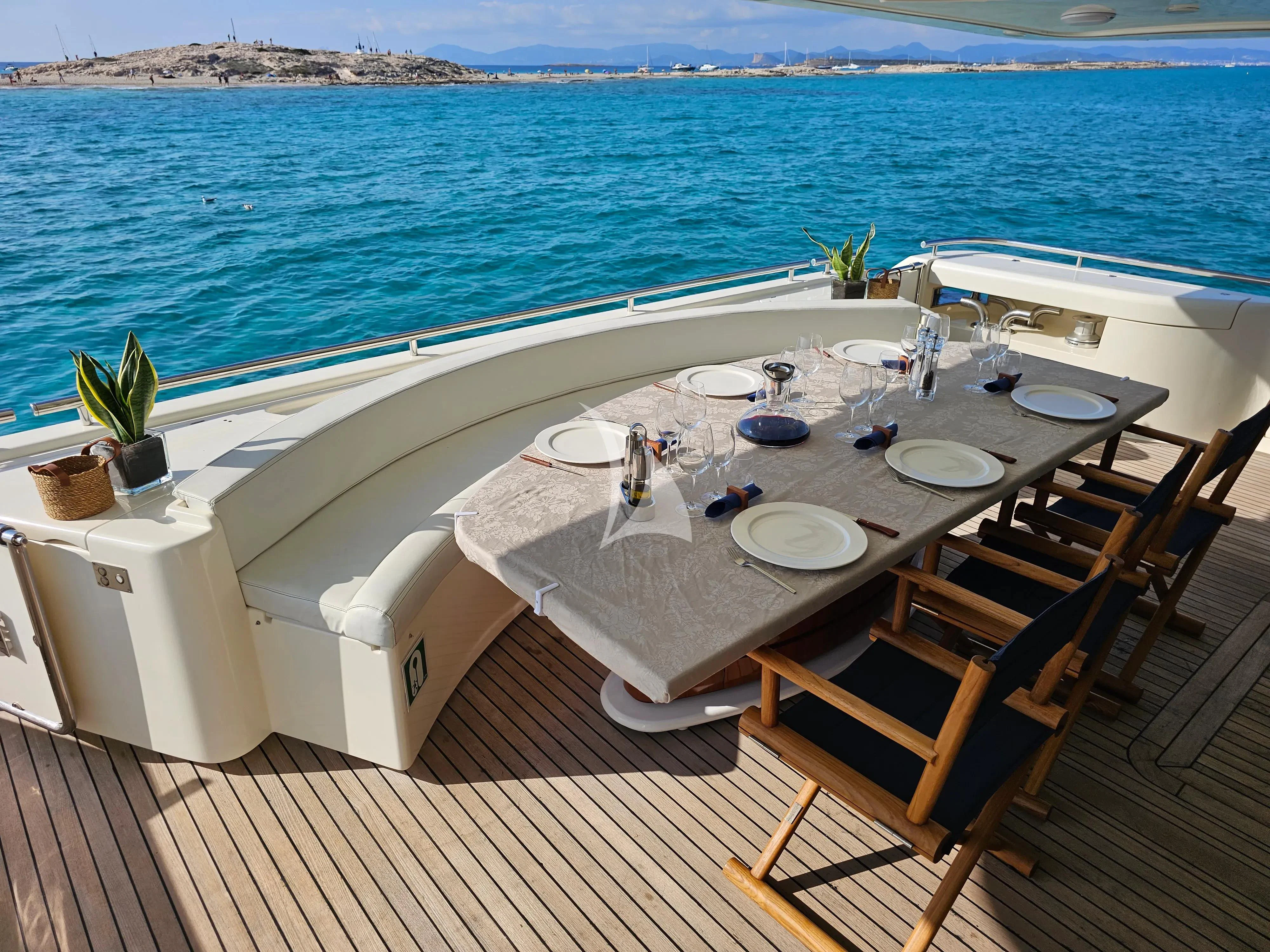 a table set on a deck overlooking the ocean aboard YOLO TOO Yacht for Charter