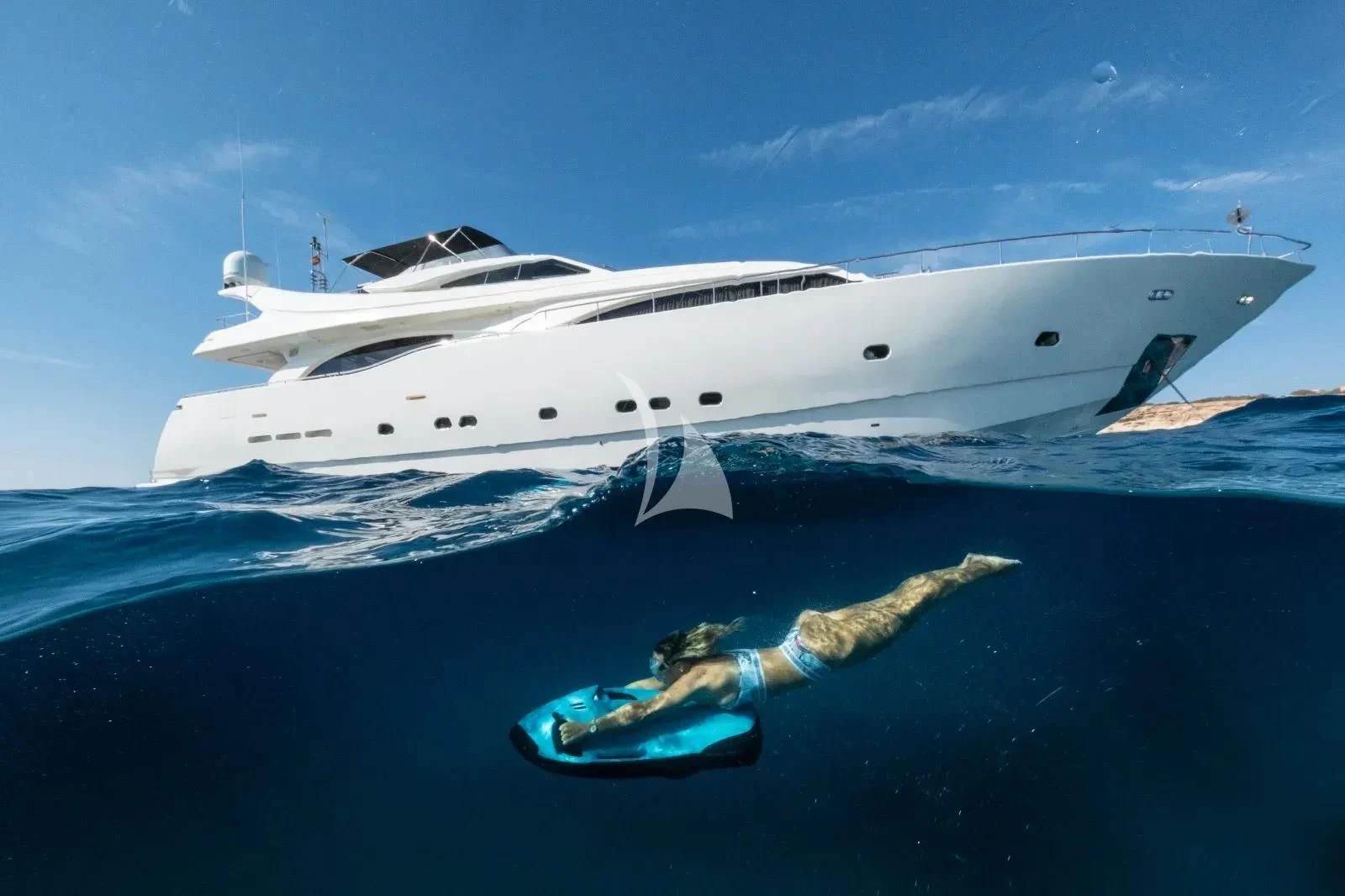 a person swimming in the water next to a white boat aboard YOLO TOO Yacht for Charter