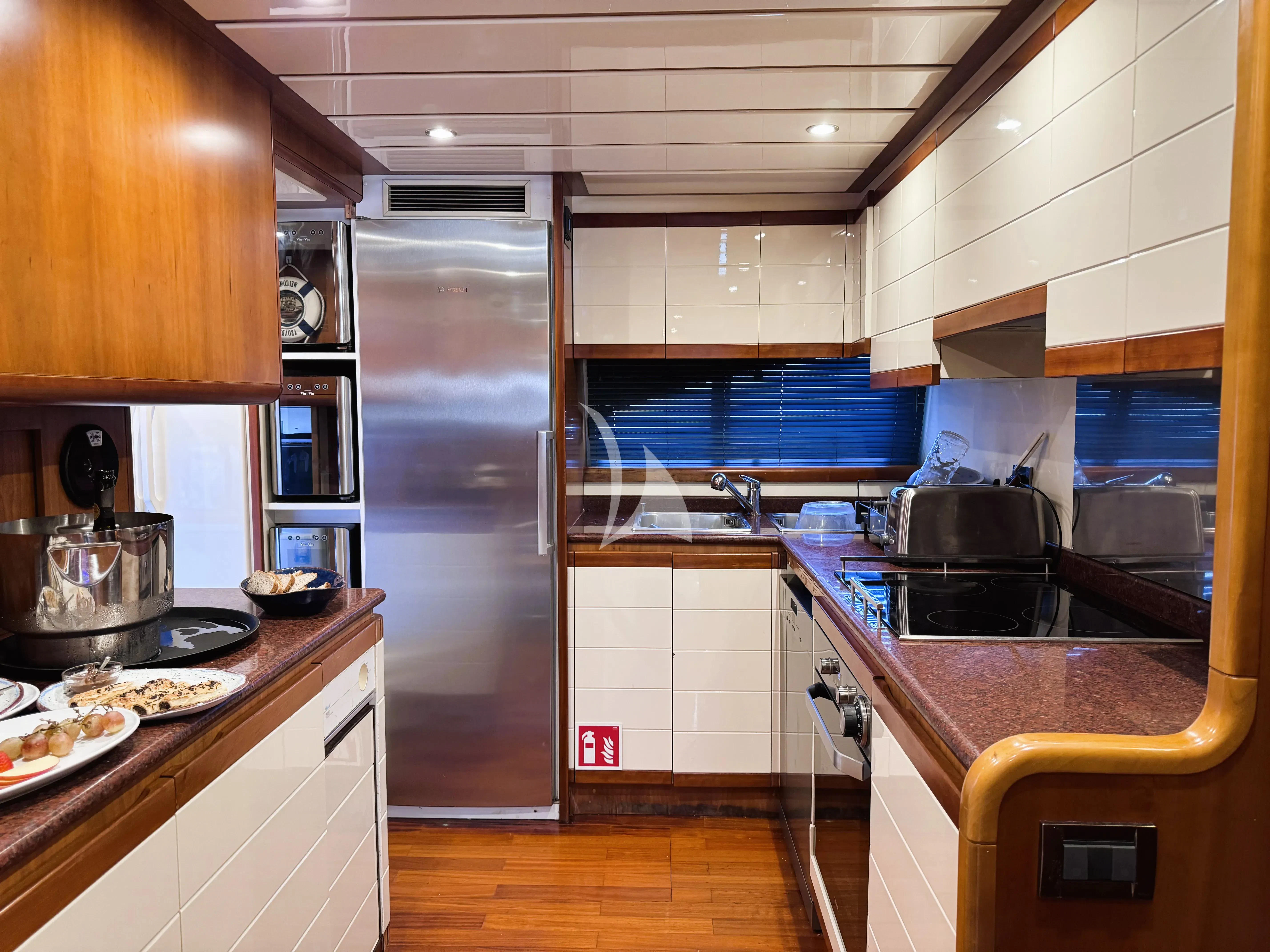 a kitchen with a stainless steel refrigerator aboard YOLO TOO Yacht for Charter