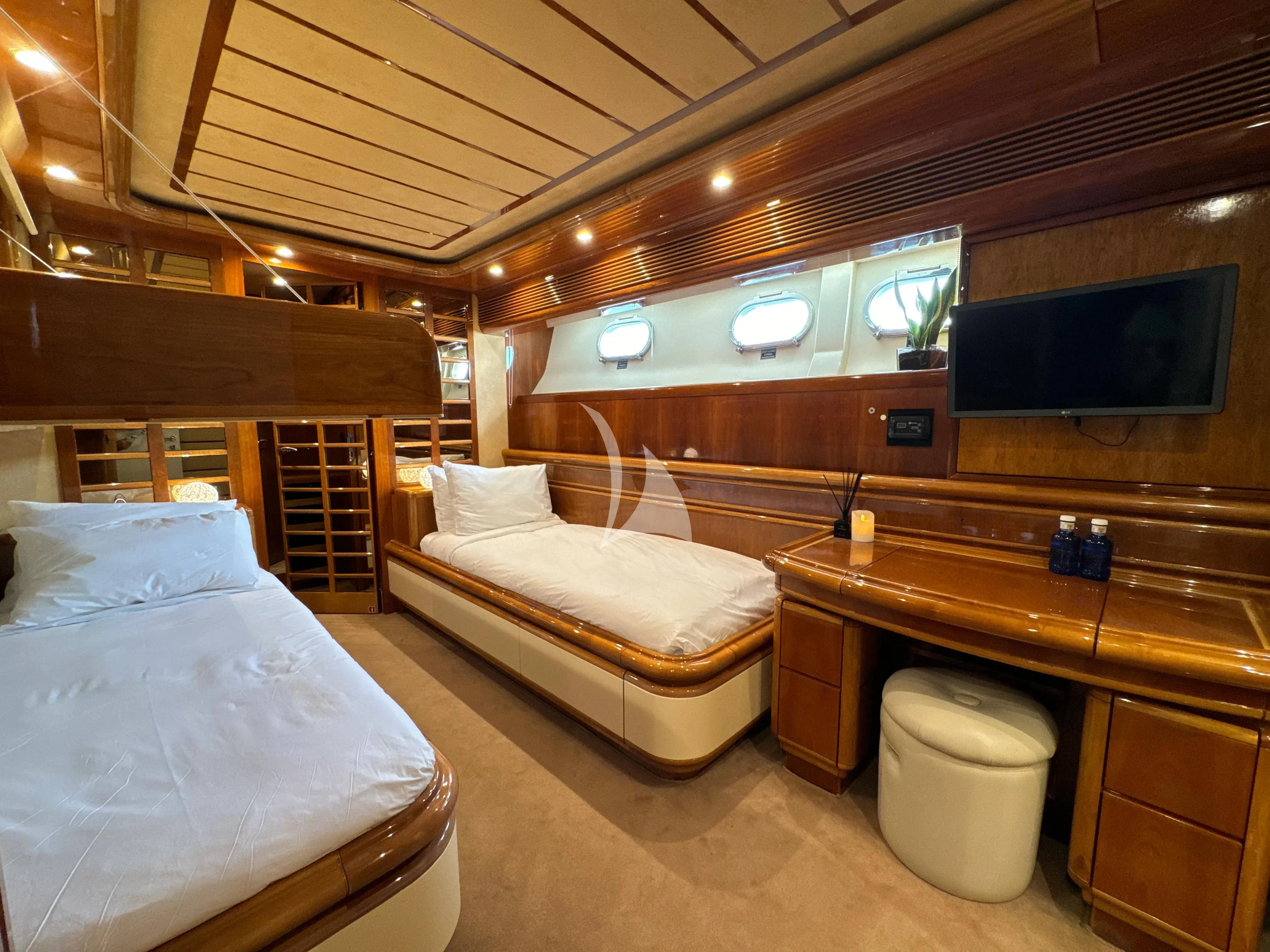 a room with beds and a tv aboard YOLO TOO Yacht for Charter