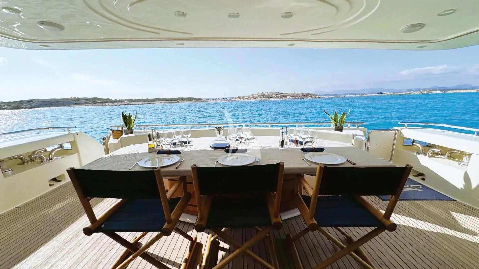 a table set for a meal on a deck overlooking the ocean aboard YOLO TOO Yacht for Charter
