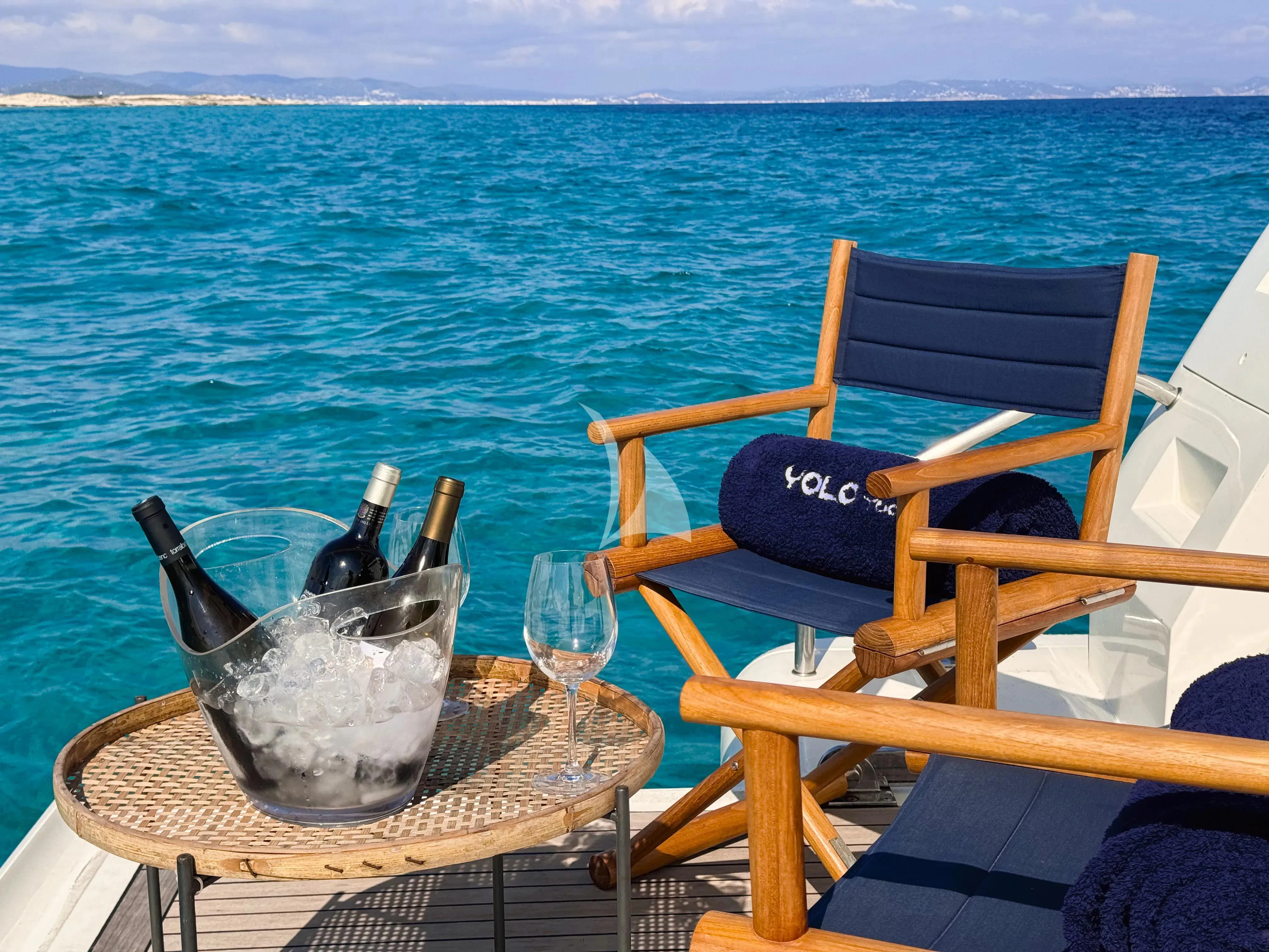a table with a bucket and a chair on it by the water aboard YOLO TOO Yacht for Charter