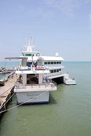 a large white boat docked at a pier aboard ASEAN LADY Yacht for Sale