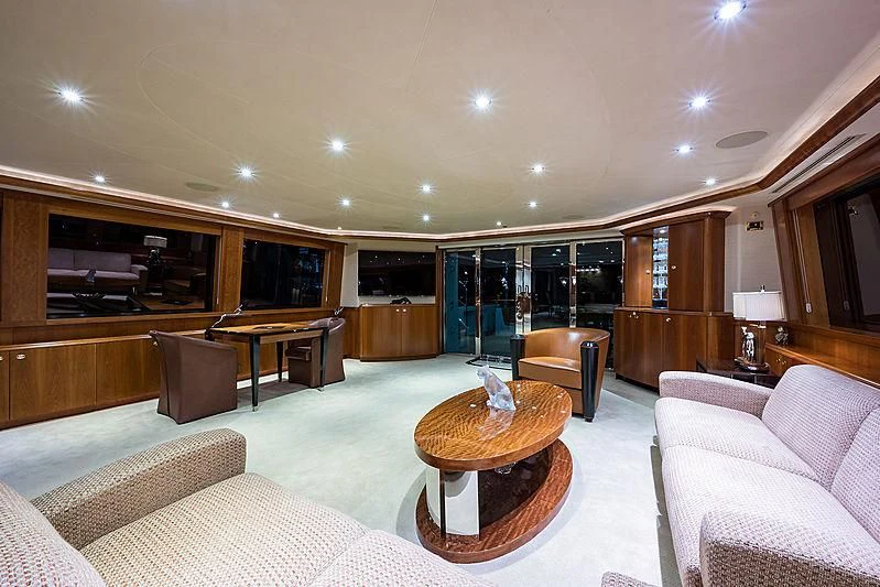 a living room with a large glass table and a large glass window aboard SLEEPOVER Yacht for Sale