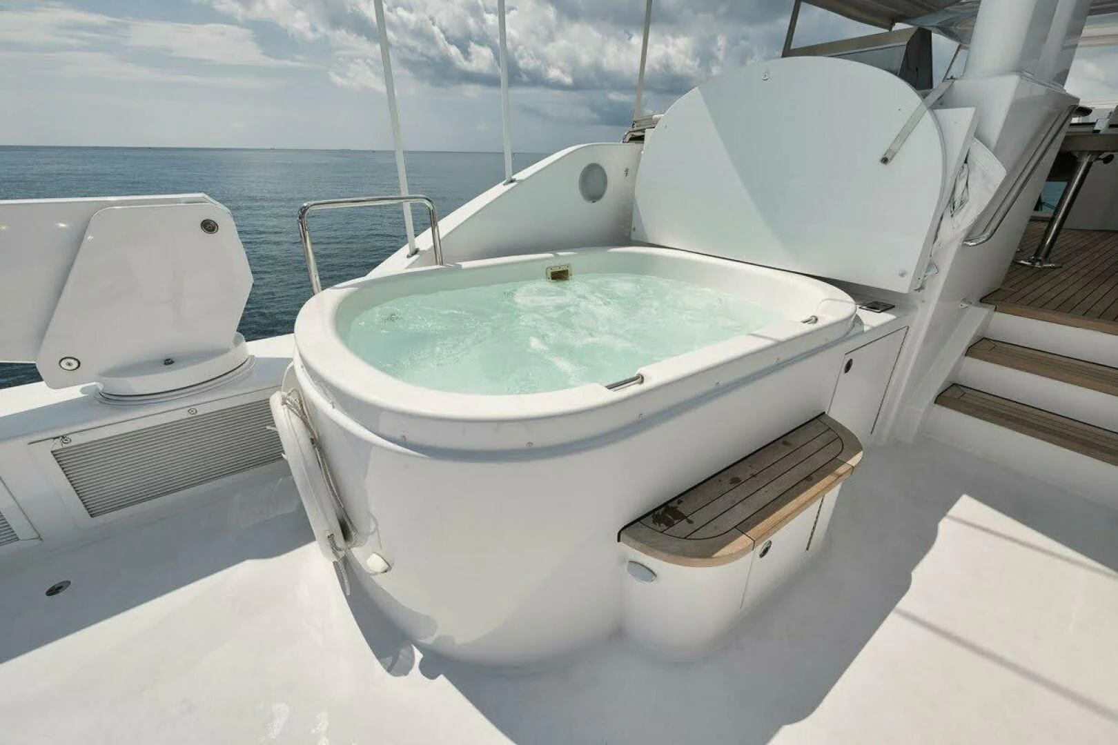 a white bathtub with a wooden seat and a wooden bench on a boat aboard SLEEPOVER Yacht for Sale