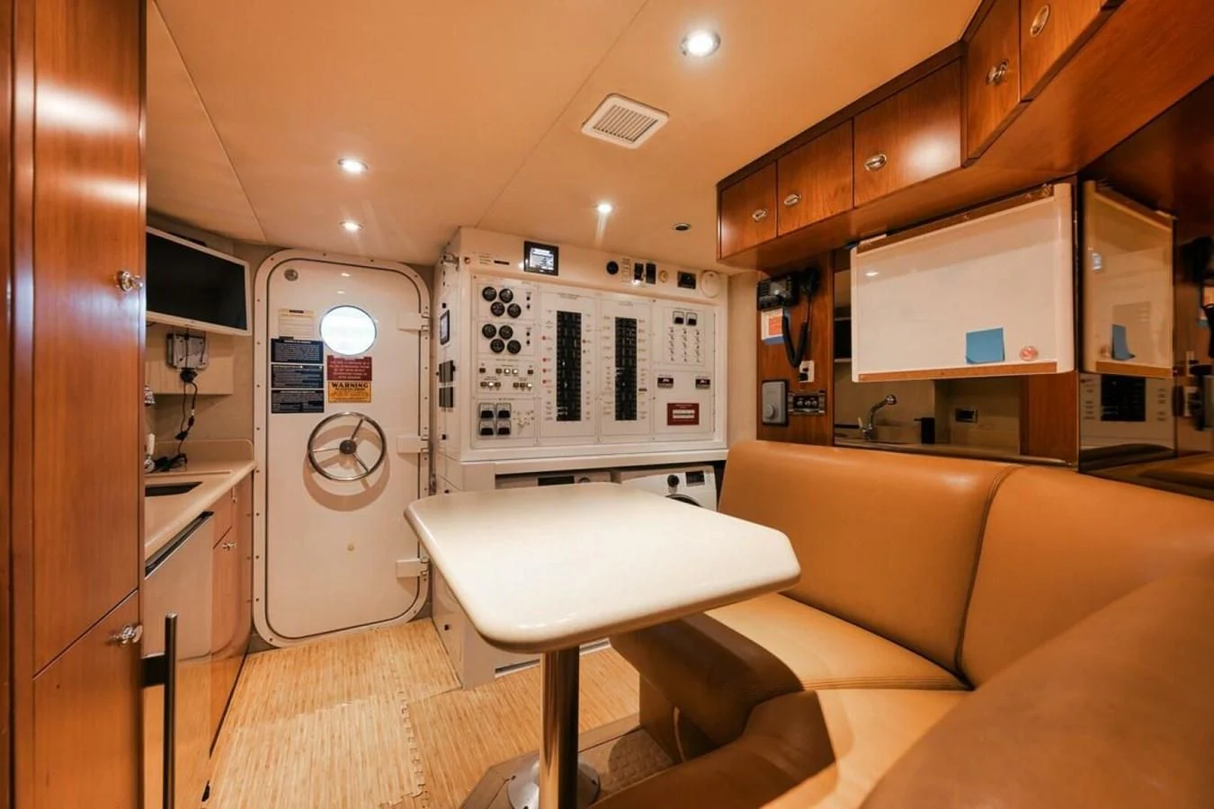a small living room with a small kitchen and a small table aboard SLEEPOVER Yacht for Sale