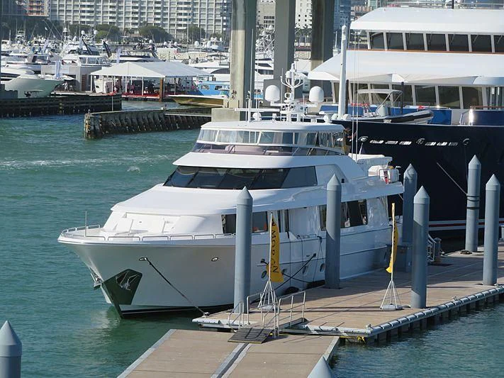 a large white boat sits at a dock aboard SLEEPOVER Yacht for Sale