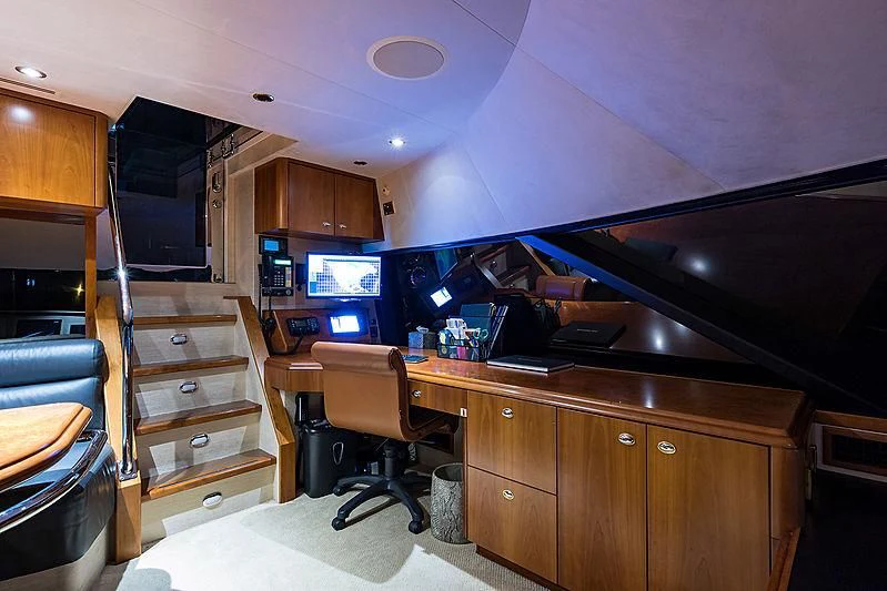 a kitchen with a wood cabinet and a television aboard SLEEPOVER Yacht for Sale