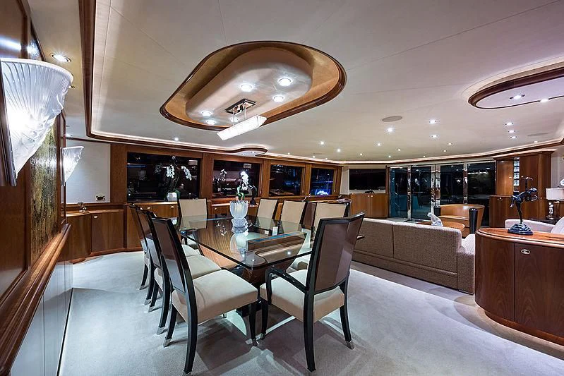 a room with a table chairs and a chandelier aboard SLEEPOVER Yacht for Sale