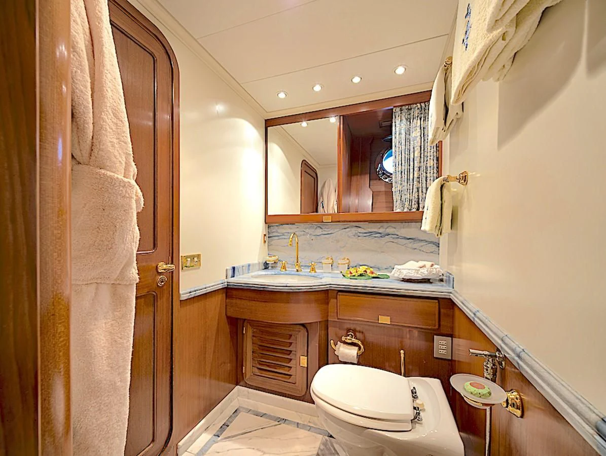 a bathroom with a sink toilet and a mirror aboard TAMARITA Yacht for Sale
