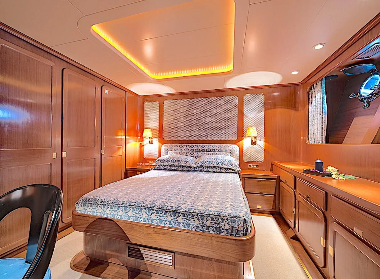 a bedroom with a bed and cabinets aboard TAMARITA Yacht for Sale
