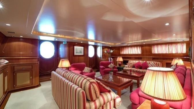 a room with a couch and a table and a lamp aboard TAMARITA Yacht for Sale