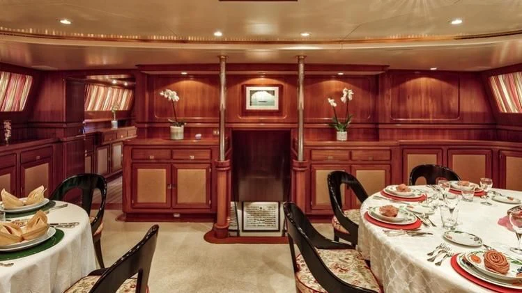 a dining room with a table set aboard TAMARITA Yacht for Sale