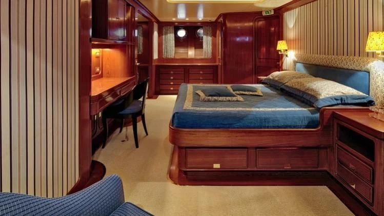 a bedroom with a bed and desk aboard TAMARITA Yacht for Sale