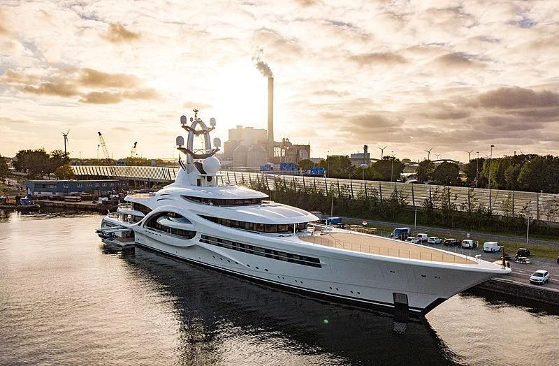 a large white boat sits in a harbor aboard AMBASSADOR Yacht for Sale