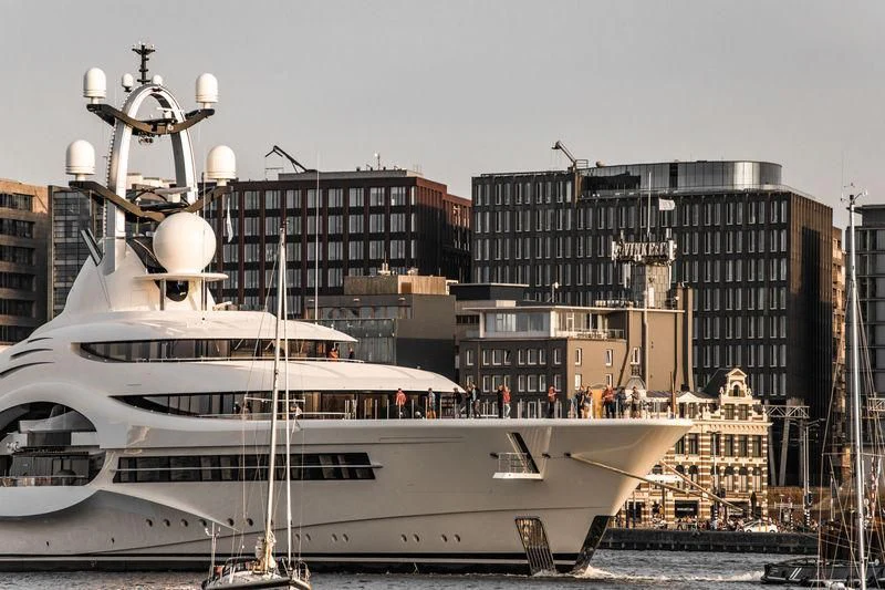 a large white boat in a harbor aboard AMBASSADOR Yacht for Sale