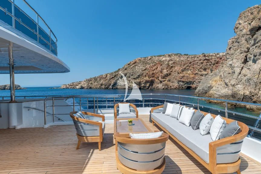 a deck with chairs and a body of water in the background aboard BOJI Yacht for Sale