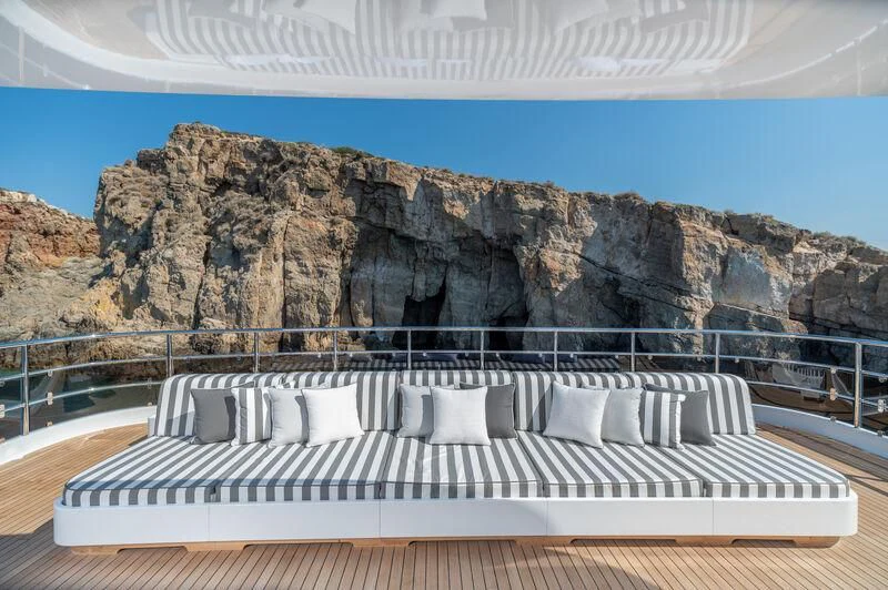 a white piano in front of a rock cliff aboard BOJI Yacht for Sale