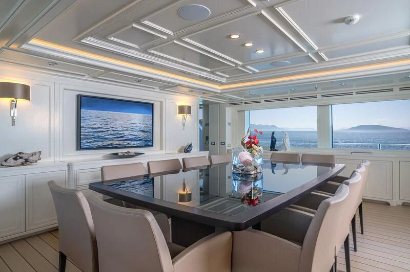 a large room with a table and chairs and a tv aboard BOJI Yacht for Sale