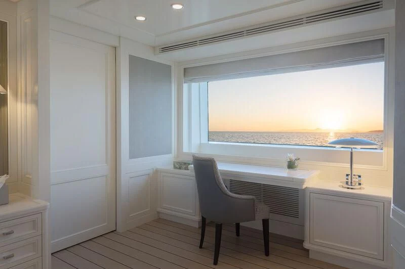 a room with a chair and a table and a window aboard BOJI Yacht for Sale