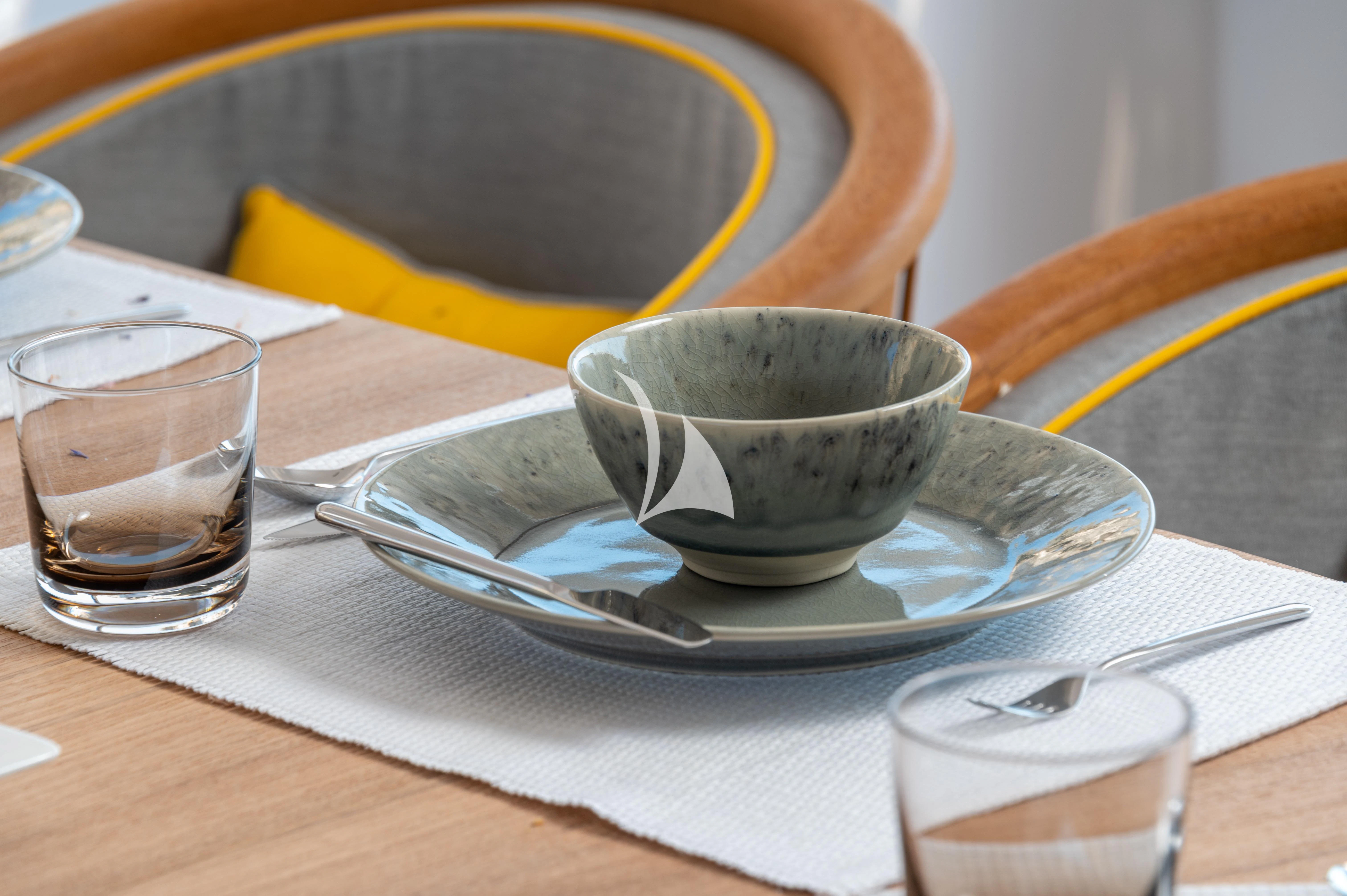 a bowl of water and a plate on a table aboard BOJI Yacht for Sale