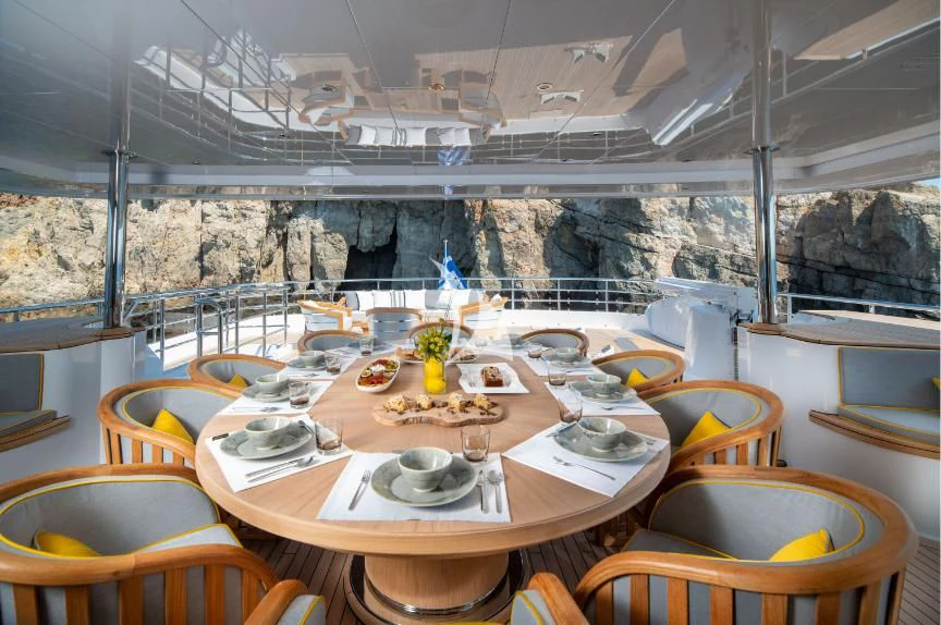 a table set with plates and glasses aboard BOJI Yacht for Sale