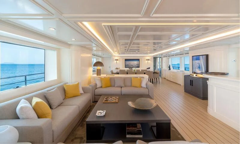 a living room with a table and couches aboard BOJI Yacht for Sale