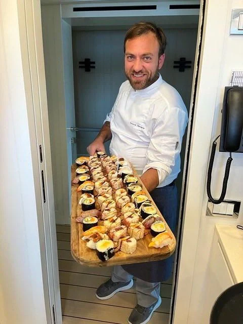 a person holding a tray of food aboard BOJI Yacht for Sale