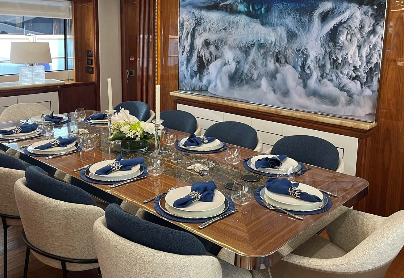 a table set with plates and chairs aboard ANYA Yacht for Sale