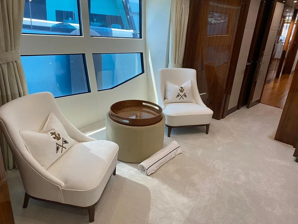 a couple of white chairs in a room with a round table and a window aboard ANYA Yacht for Sale