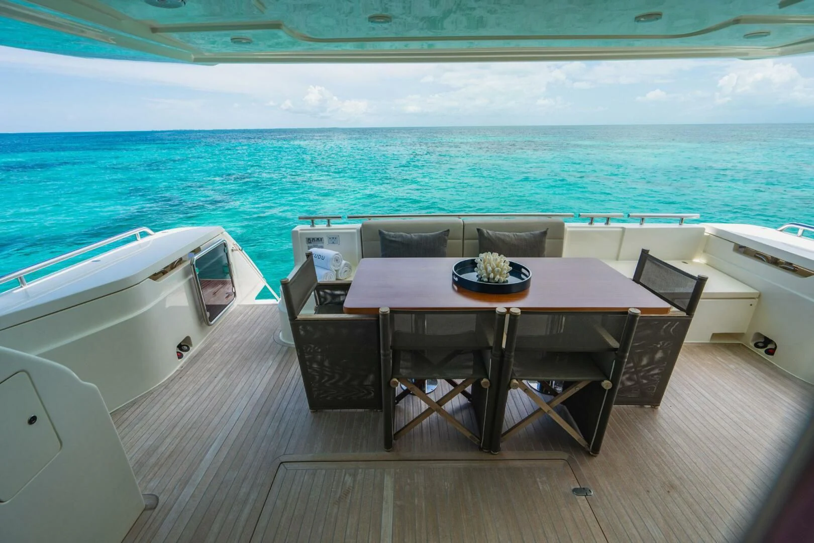 a table and chairs on a deck overlooking the ocean aboard KUDU Yacht for Sale