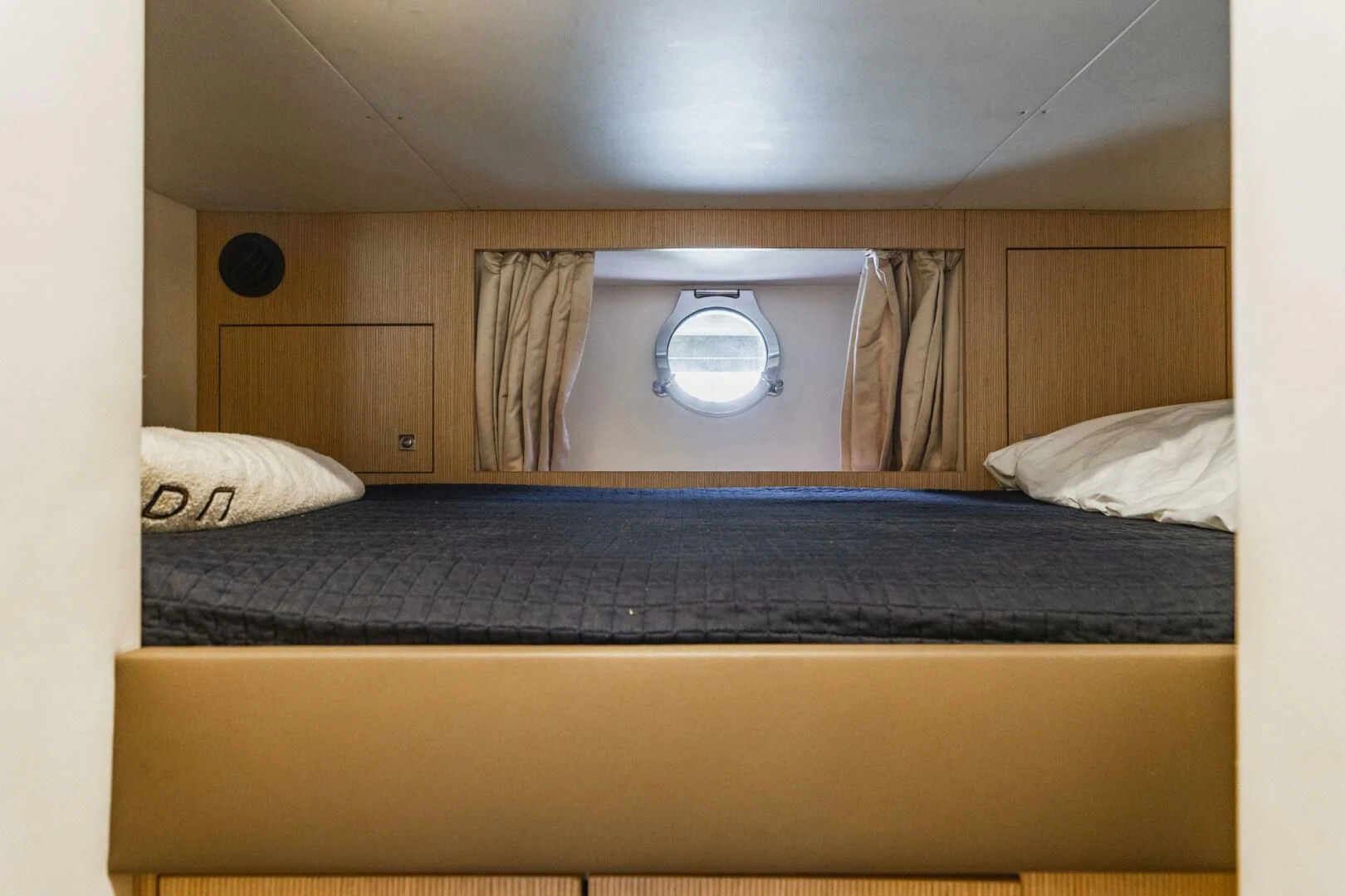 a bed with a blue blanket aboard KUDU Yacht for Sale